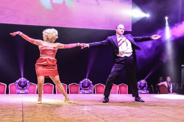 A group of boxers pose with their fists raised in a boxing ring.